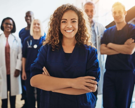 a group of people standing in front of a person in blue scrubs