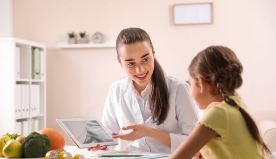 a person showing a tablet to a child