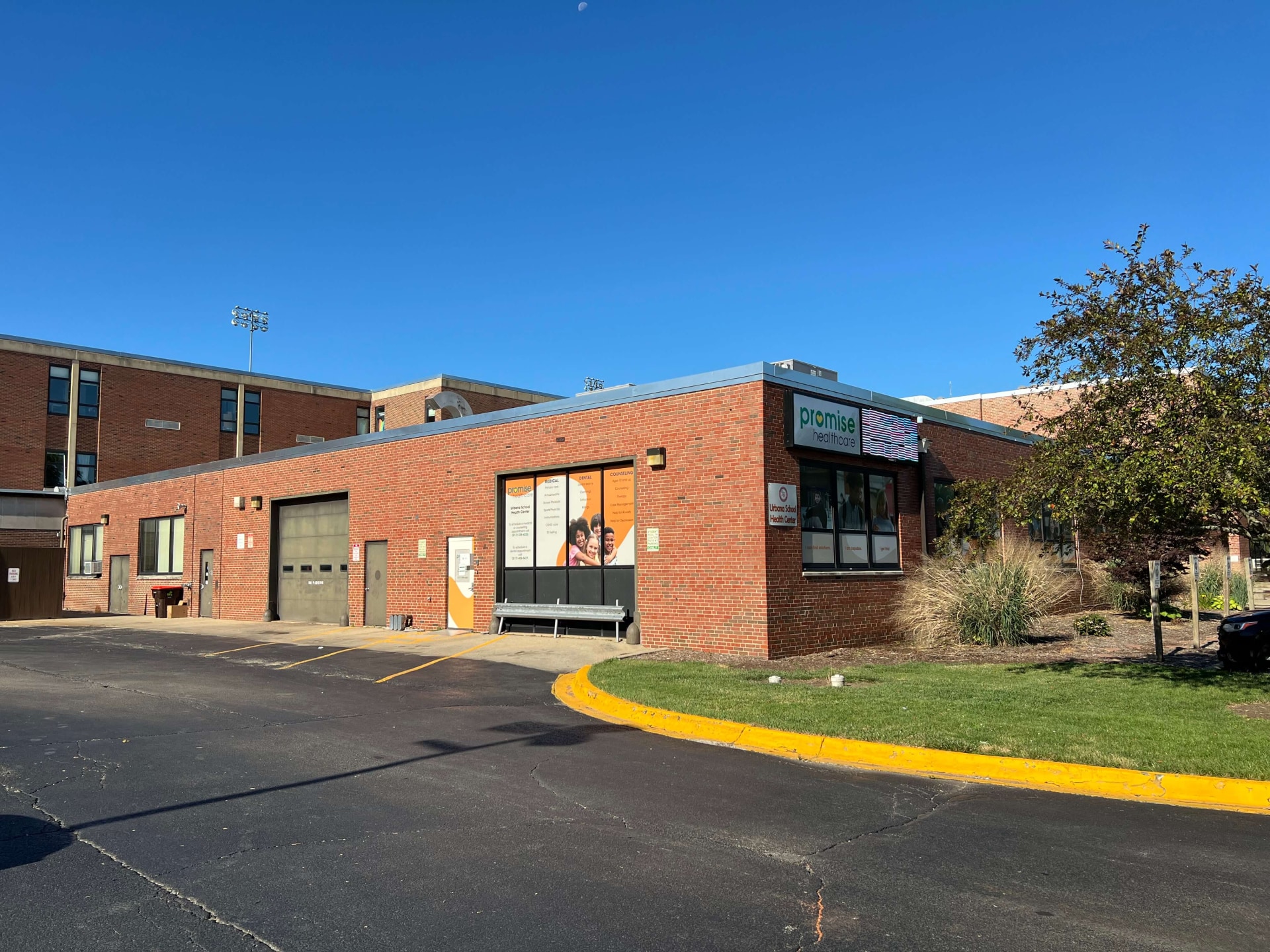 a brick building with a parking lot and a tree